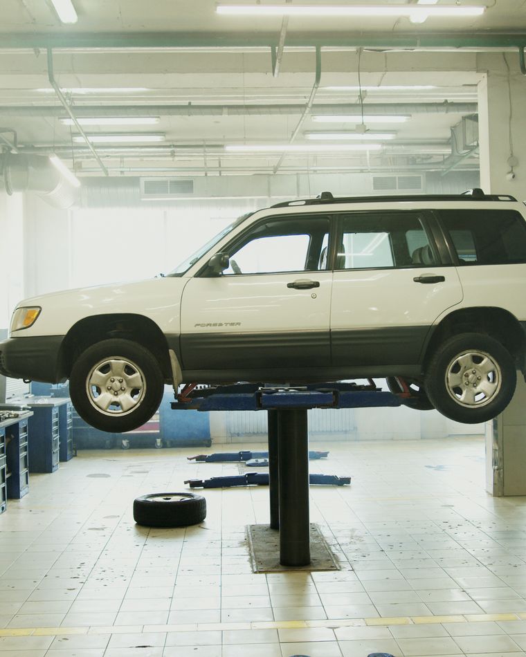 Car raised on a hydraulic lift in the service bay